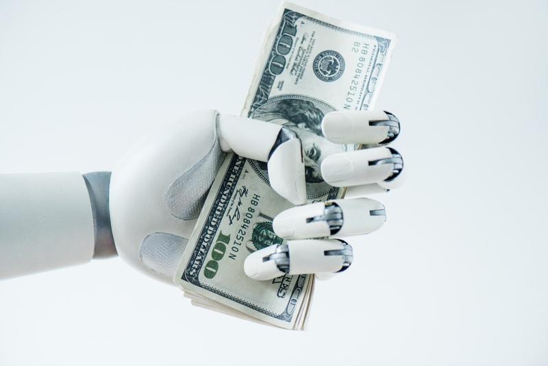 close-up view of robot holding dollar banknotes isolated on white