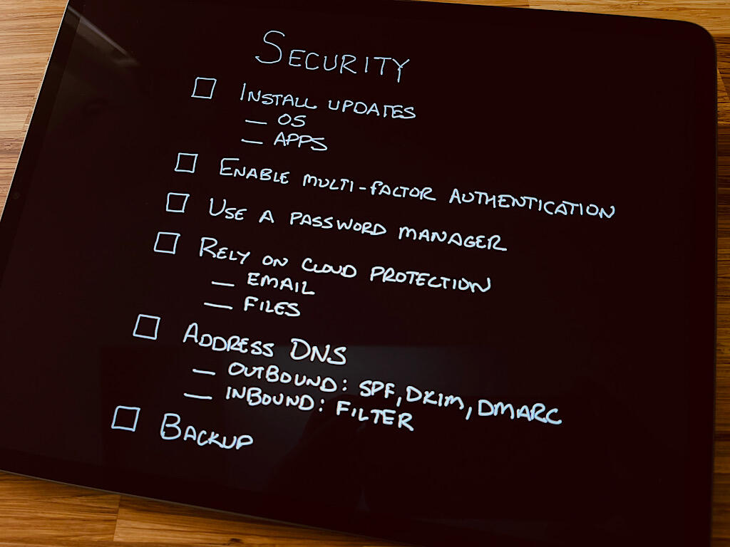 Photo of an iPad with an image: title "Security" with six checkboxes (one for each item): Install updates, Enable multi-factor authentication, Use a password manager, Rely on cloud protection, Address DNS, and Backup.