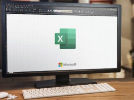 Microsoft Office Excel on computer screen. Monitor, keyboard and airpods on wooden table. Selective focus. Rio de Janeiro, RJ, Brazil. January 2022