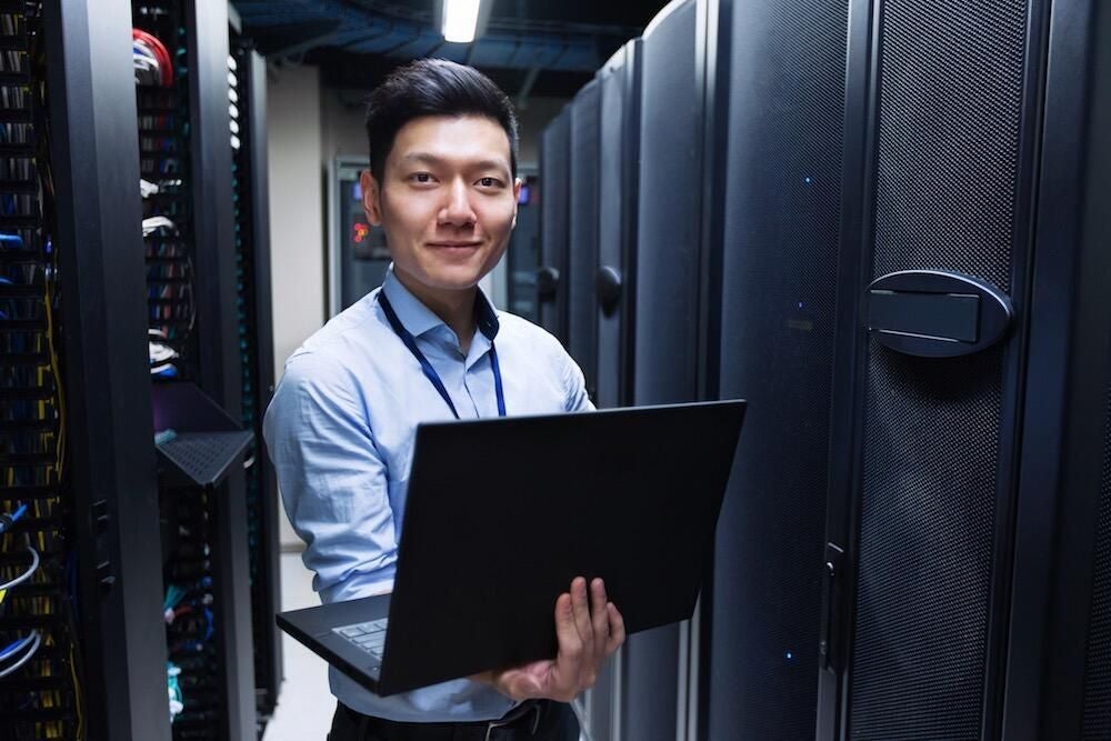 IT engineer standing at servers in data center