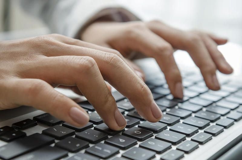 Photograph of hands working on data entry with keyboard