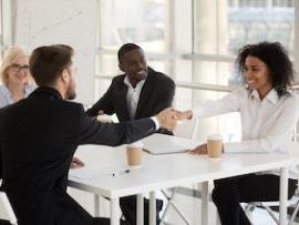Diverse businesspeople shaking hands during meeting in office