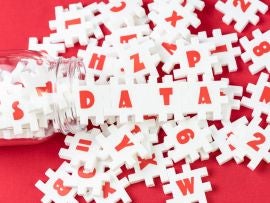 Big data analysis, unstructured database processing metaphor, large volume of white puzzle jigsaws with alphabets pouring from bottle combine word DATA on red fabric background with copy space