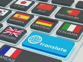 Foreign languages translation concept, online translator, macro view of computer keyboard with national flags of world countries on keys and blue translate button