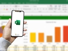 Microsoft Excel app on smartphone screen and Microsoft Excel program background on computer screen.