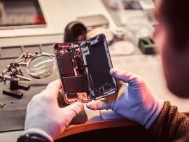 Technician carefully examines the integrity of the internal elements of the smartphone in a modern repair shop