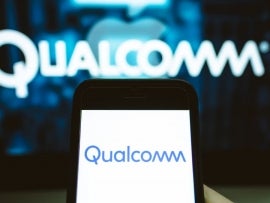 User holds a smartphone displaying Qualcomm's logo