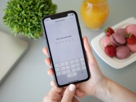 Woman hand holding iPhone 11 with Pin code on screen