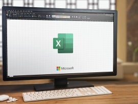 Microsoft Office Excel on computer screen. Monitor, keyboard and airpods on wooden table. Selective focus. Rio de Janeiro, RJ, Brazil. January 2022