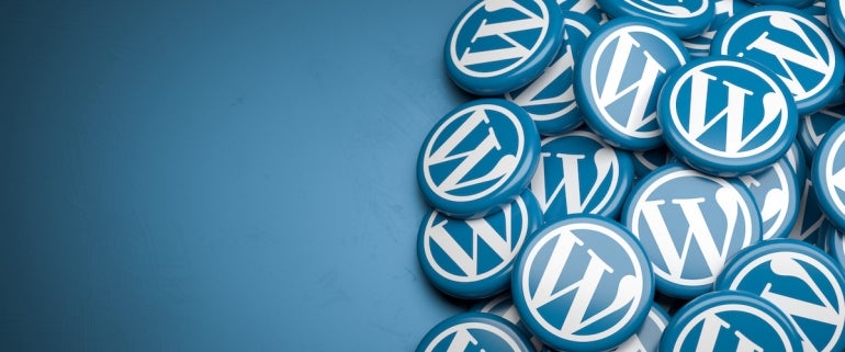 Logos des WordPress-Web-Content-Management-Systems auf einem Stapel auf einem Tisch.  Platz kopieren.  Web-Banner-Format.