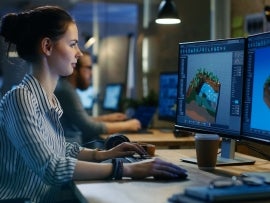 Female Game Developer Works on a Level Design on Her Personal Computer with Two Displays. She works in a Creative Office Space.