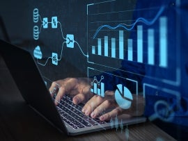 Analyst working with Business Analytics and Data Management System on computer.