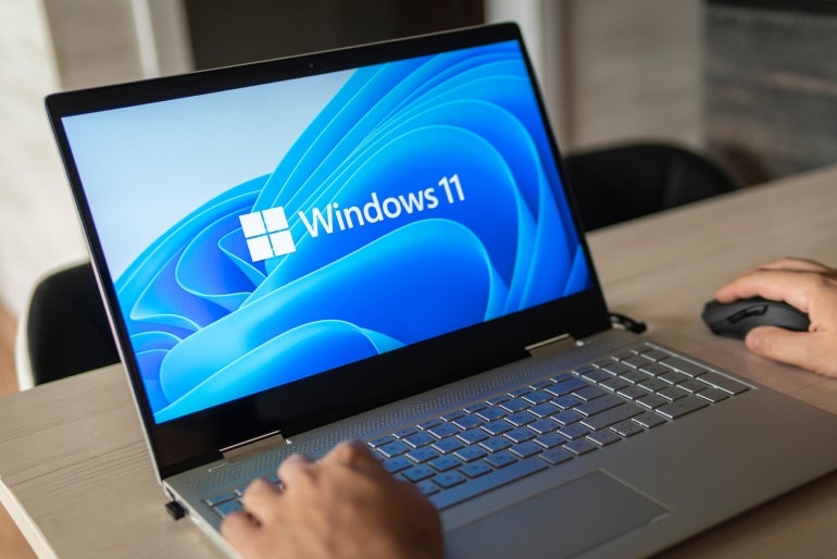 Windows 11 logo on laptop screen.