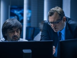 Government Chief of Cyber Security Consults Operations Officer who Works on Computer. Specialists Working on Computers in System Control Room.