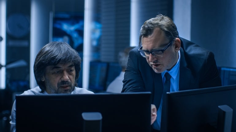 Two digital forensics cybersecurity experts investigate a case.