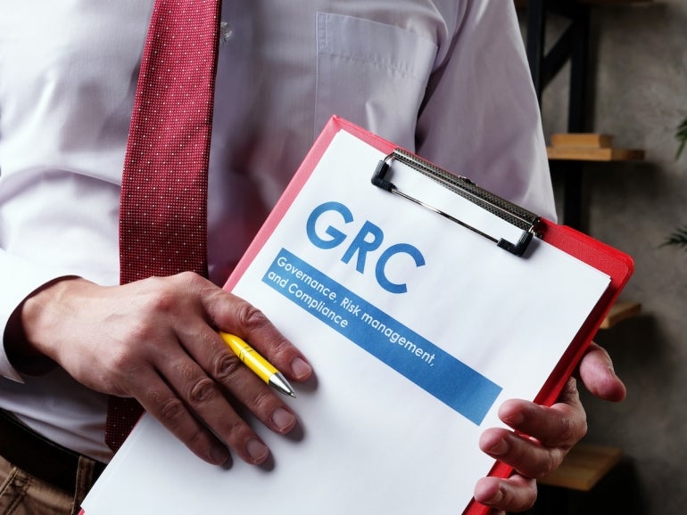 Businessman with GRC Governance risk management and compliance documents.