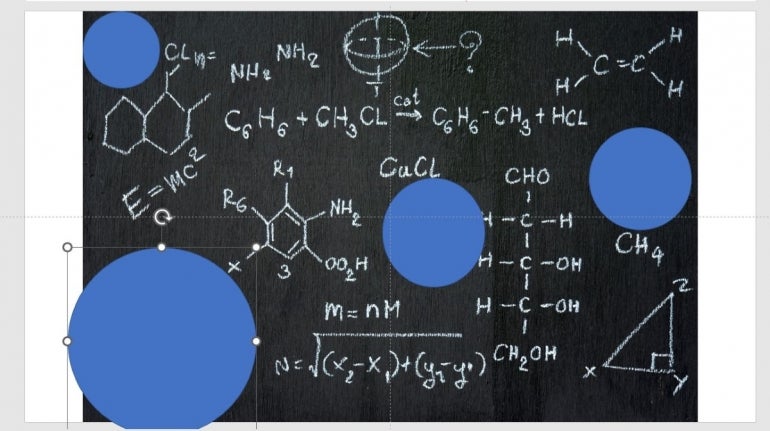 Four blue circles of varying size over writing on a chalkboard.