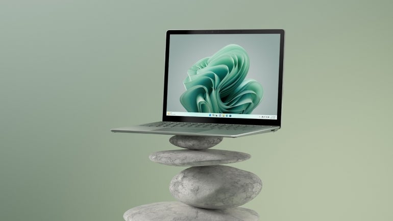 a Surface Laptop 5 balanced on top of some rocks