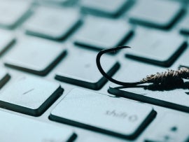 Phishing and cyber crime concept. fishing hook on computer keyboard. copy space