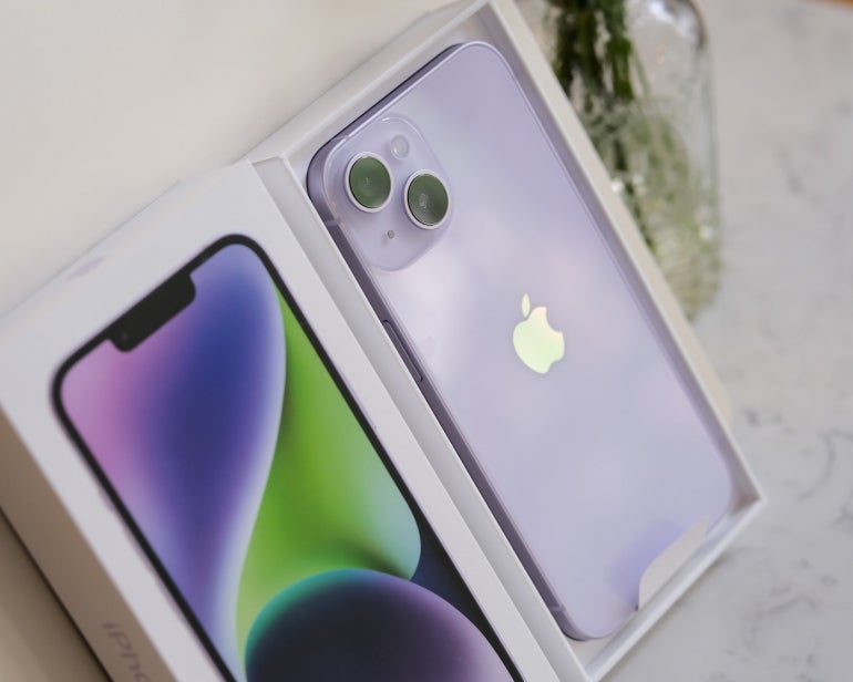 A purple iPhone 14 in its box.