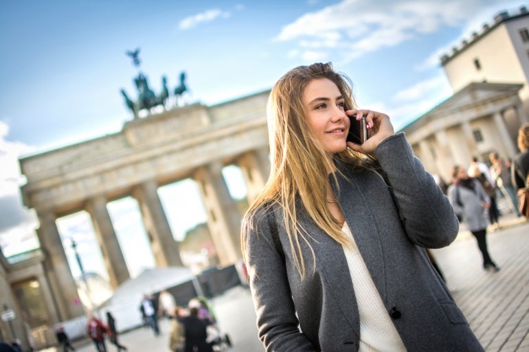 Beautiful young woman in smart casual wear talking on mobile phone outdoors.