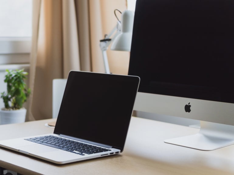 Closeup of a Macbook and Mac desktop.