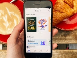 an iPhone being held over a meal with the Headway app open