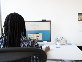 Woman using Trello on a computer.