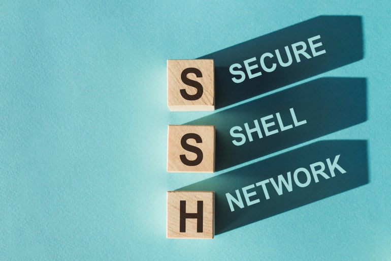 Wooden cubes building word SSH - (abbreviation Secure Shell Network) on light blue background.