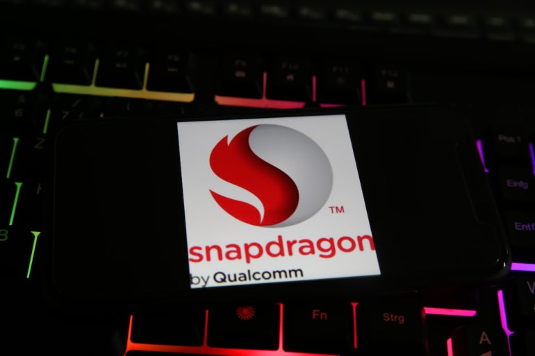 Closeup of smartphone with logo lettering of snapdragon qualcomm processor cpu on computer keyboard