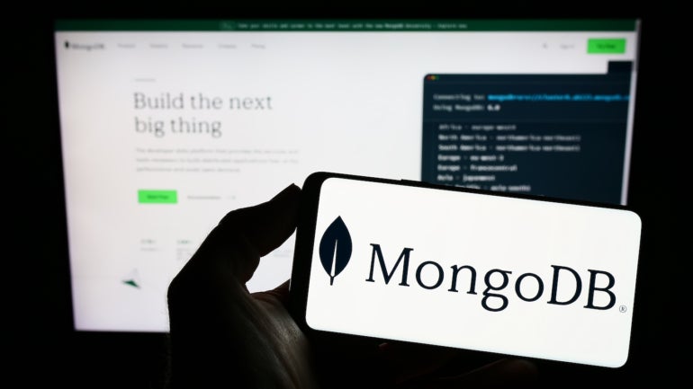 The MongoDB logo on a phone in front of their website.