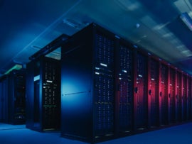 Dark room full of data servers backlit in blue and red