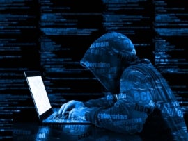 A hacker in a blue hoody with cyber security threats printed all over him.