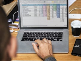 A businessman using a spreadsheet program on a laptop.