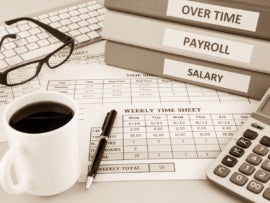 Human resources documents: payroll, salary and employee time sheets place on office table with cup of coffee and calculator, sepia tone.