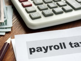 Payroll tax concept, papers, calculator and money.